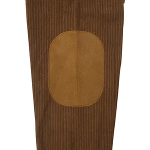 Macro detail of men's brown corduroy sweatshirt fabric showing suede elbow patch texture