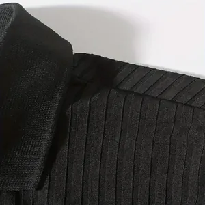 Gedetailleerd macro-overzicht van de zwarte geribbelde textuur en kraag van dit heren poloshirt