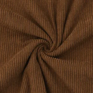 Detailed macro view showing the soft textured ribs of premium brown corduroy fabric