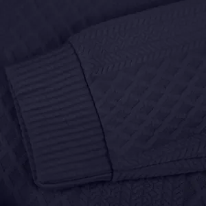 Primer plano del puño acanalado y tejido jacquard de una sudadera azul marino para hombre