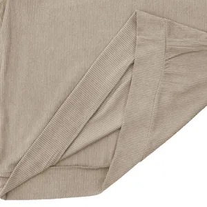 Detailed texture of beige corduroy fabric and hem stitching on a men's sweatshirt