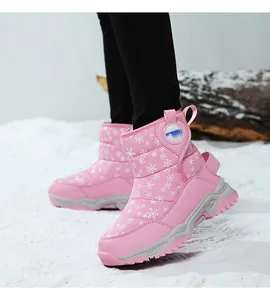 Dettaglio di stivali da neve rosa per bambini con motivi a fiocchi di neve bianchi