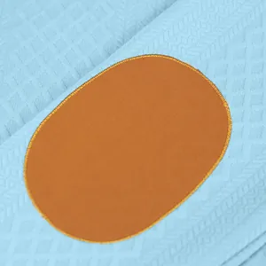 Primer plano del tejido de punto jacquard con un parche ovalado en sudadera hombre