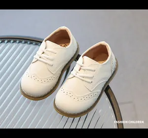 Detail view of white soft leather children's brogue shoes with perforated wingtip.