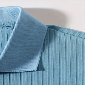 Detailopname van de kraag en schoudernaad van een lichtblauwe gebreide rib-poloshirt