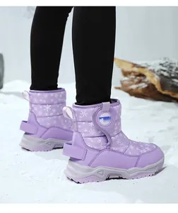 Vista dettagliata degli stivali da neve viola per bambini con motivo a fiocchi.