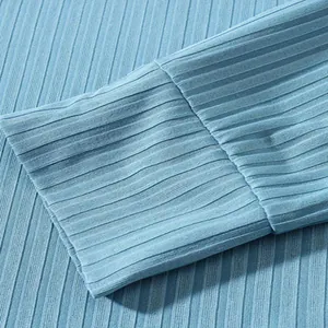 Detailopname van lichtblauwe geribbelde breistructuur en manchet van herenpolo met lange mouwen