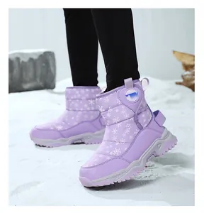 Dettaglio stivali da neve viola per bambini con stampa di fiocchi di neve e suola.