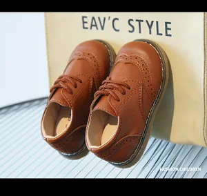 Detail view of stylish brown leather brogue shoes for children with classic lace-up design