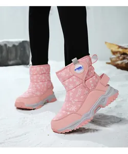 Stivali da neve rosa per bambini con motivi a fiocchi di neve in una scena innevata.