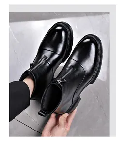 Vista detallada de elegantes botas Chelsea de cuero negro para hombre con cremallera frontal