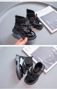 Detailansicht der stilvollen schwarzen Lackleder-Söckchenstiefel für Mädchen mit großer Schleife.