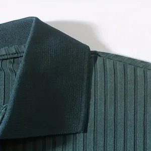 Detailopname van de verticale geribbelde stof en kraagdetails van een groen poloshirt voor heren