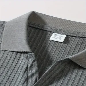 Detailweergave van de kraag en geribbelde textuur van een grijze casual herenpolo