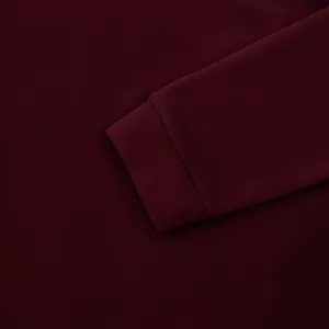 Gedetailleerd overzicht van de geribbelde manchet van een donker bordeauxrood shirt