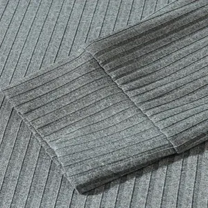 Macro-detail van grijze geribbelde stof en stiksels op een heren poloshirt met lange mouwen