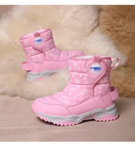 Detail view of pink children's snow boots with white snowflake patterns and fur lining