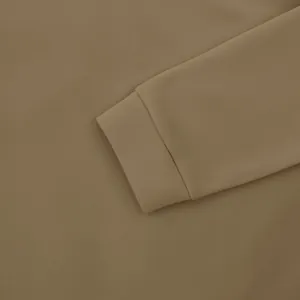 Detailopname van de manchet van een kaki shirt met lange mouwen met fijne stoftextuur.