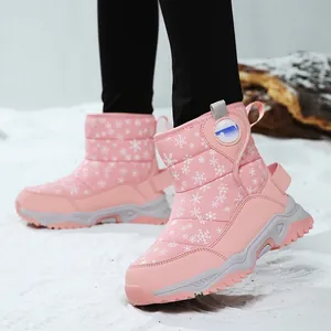 Pink children's high-top snow boots with white snowflake patterns on artificial snow
