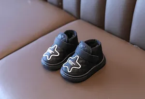 Detail of warm black baby snow boots featuring white star decoration and quilted texture design