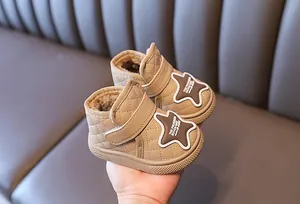 Close-up of quilted beige baby snow boots with warm fleece lining and star patch