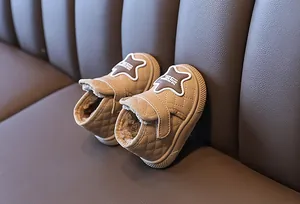 Close-up detail of khaki quilted baby snow boots featuring a warm fleece lining and star patch