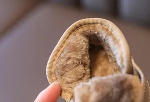 Detailed macro view showing the thick faux fur lining inside warm winter snow boots for kids