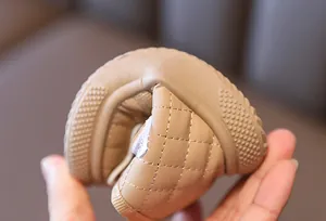 Flexible sole detail of beige quilted baby walking shoes with warm lining