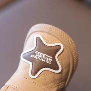 Close-up of beige quilted winter baby snow boots featuring a decorative star patch