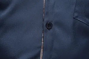 Détail rapproché d'une chemise bleu marine pour homme avec patte boutonnée à carreaux