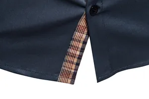 Vue macro d'une chemise homme bleu marine montrant la doublure de l'ourlet à carreaux