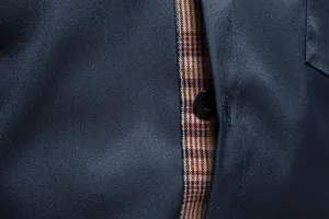 Détail d'une chemise habillée pour homme montrant la patte de boutonnage à carreaux