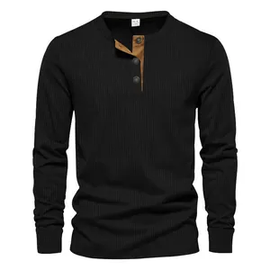 Détail de la texture côtelée et de la patte contrastée marron sur un t-shirt Henley noir pour homme