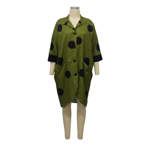 Vue de face détaillée d'une robe chemise vert olive à pois avec manches 3/4 et poches.