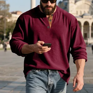 Homme en ville portant un sweat-shirt décontracté en velours côtelé bordeaux à manches longues
