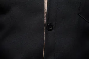 Gros plan détaillé du tissu de chemise noire pour hommes avec patte boutonnée à carreaux rétro.