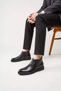 Nahaufnahme von schwarzen Chelsea-Boots aus Leder für Herren in eleganter Sitzposition