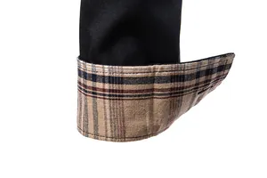 Gros plan d'une manche de chemise noire pour homme avec une doublure à carreaux rétro