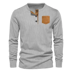 Detail of men's grey ribbed Henley shirt featuring a brown contrast chest pocket.
