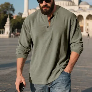 Détail d'un sweat-shirt en velours côtelé vert olive pour homme avec col henley.