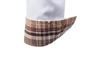 Gros-plan sur le poignet d'une chemise blanche pour homme avec doublure à carreaux rétro.