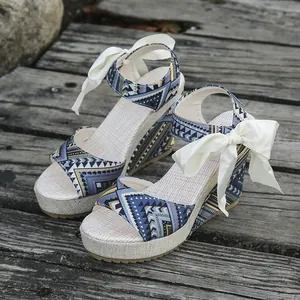 Close-up of ethnic wedge sandals with geometric patterns and silk bow ties
