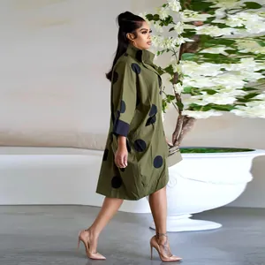 Vue latérale d'une robe chemise vert olive à pois avec poches et manches trois-quarts
