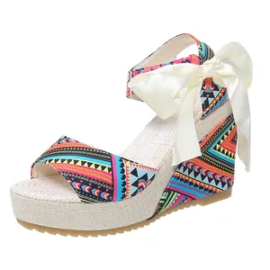 Ethnic style wedge peep toe sandals with vibrant pattern and a large cream satin bow