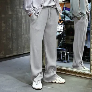 Vista completa de pantalones casuales de canalé gris para hombre con corte recto holgado.
