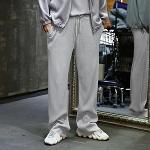 Primer plano de pantalones anchos de hombre grises con rayas verticales plisadas