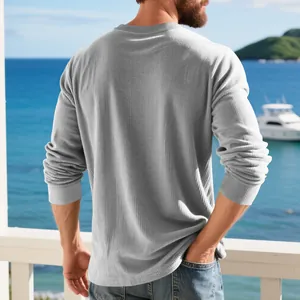 Vue arrière d'un sweat-shirt à manches longues côtelé gris pour hommes sur un balcon face mer.