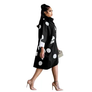 Vue de côté élégante d'une robe chemise noire à pois blancs avec des poches pratiques