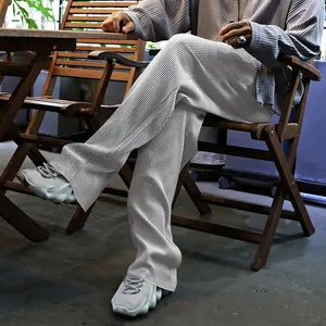 Primer plano de la textura de tela plisada gris en estos pantalones anchos de hombre.