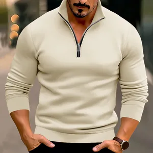 Detailopname van crèmekleurige herenpullover met kwartritssluiting en opstaande kraag